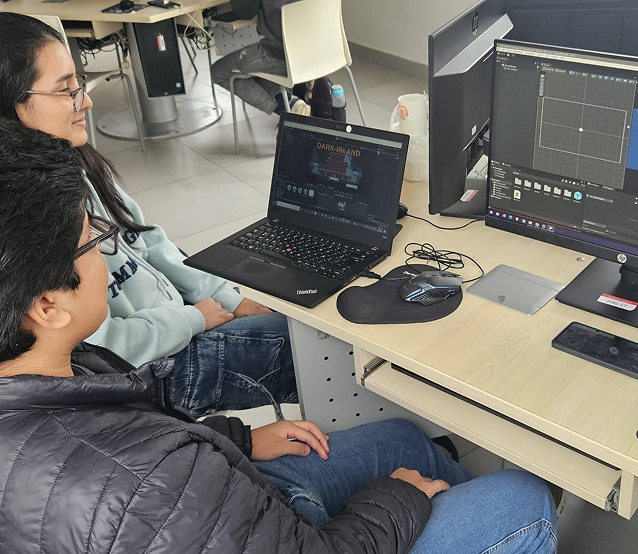 Imagen de jóvenes estudiantes de ingeniería viendo una laptop y un monitor
